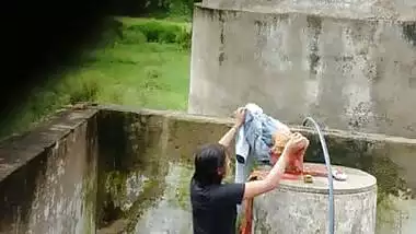 Indian village girl bathing near water tank outdoor